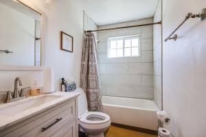 a bathroom with a toilet and a tub and a sink at Central Menomonee Falls Condo WFH Friendly in Menomonee Falls +16 photos