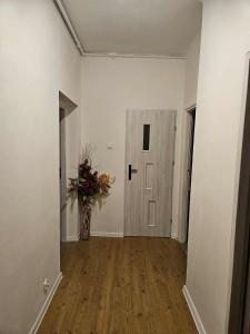 un corridoio con un vaso di fiori accanto a una porta di Apartament Zielony Zakątek a Dąbrowa Górnicza 1 altra foto