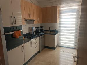 kuchnia z białymi urządzeniami i drewnianymi szafkami w obiekcie Élégant appartement moderne au cœur d Agadir Bay w mieście Agadir +7 zdjęć