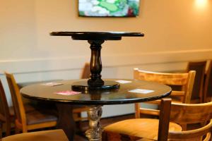 a table with a black top on a table with chairs at The Castle Inn in Wigmore