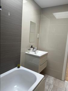a bathroom with a white tub and a sink at Manu Double Room in London