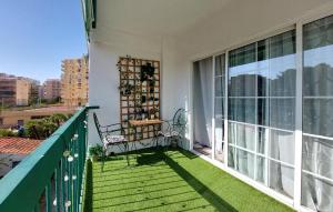 un balcone con due sedie e un tavolo di Nice Apartment In Puebla De Farnals a Las Canteras