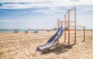 un parco giochi su una spiaggia con persone in acqua di Nice Apartment In Puebla De Farnals a Las Canteras Altre 16 foto