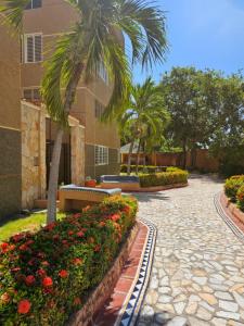 eine Palme und Blumen in einem Innenhof mit einem Gebäude in der Unterkunft Apartamento Moderno Margarita in El Valle del Espíritu Santo