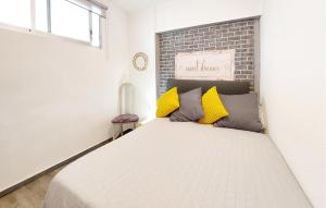 una camera da letto con un letto con cuscini gialli e grigi di Nice Apartment In Puebla De Farnals a Las Canteras