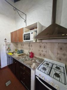 a kitchen with a stove and a microwave at Chuhouse in Villa Gesell