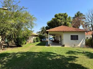 a house in a yard with a grass field at Cute Rustic Cottage by the River in Caximba