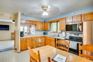 une cuisine avec des armoires en bois et une table en bois dans l'établissement Waterfront Fond du Lac Home on DeNeveu Lake!, à Fond du Lac