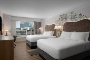 a hotel room with two beds and a large window at The Grove Hotel in Boise