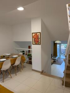a dining room and living room with a table and chairs at Vila Verde TownHouse T53 by RPG Group in Santa Maria