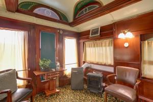 a living room with a chair and a table and a desk at The Presidential Stay, Converted Railcar in DuBois in Adrian Furnace