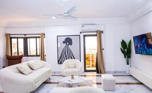 una sala de estar blanca con un sofá blanco y sillas en Calm loft - Fidjrosse 5min plage, en Cotonou
