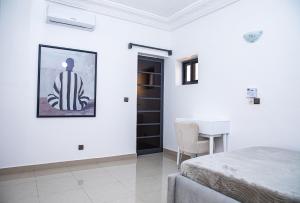Un dormitorio blanco con una cama y una mesa. en Calm loft - Fidjrosse 5min plage, en Cotonou