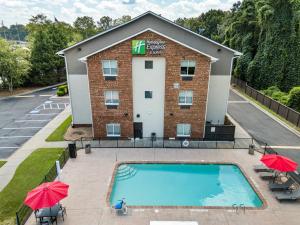 an image of a hotel with a pool and umbrellas at Holiday Inn Express & Suites Buford NE - Lake Lanier by IHG in Buford