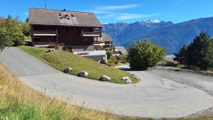 a building with sheep on the side of a road at Centre Thermal - Studio SUD terrasse in Ovronnaz +5 photos