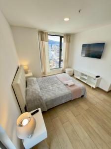 キトにあるLuxury Mini Suite, La Carolinaのベッドと大きな窓のある寝室