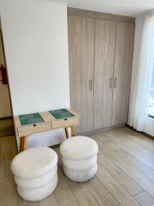 キトにあるLuxury Mini Suite, La Carolinaのデスク、スツール2脚、テーブルが備わる客室です。