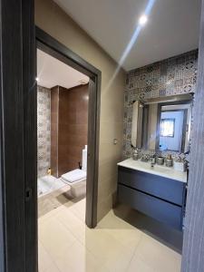 a bathroom with a sink and a toilet and a mirror at Cozy apartment Beach and Souk within walking distance in Tangier
