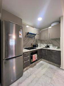 a kitchen with a stainless steel refrigerator and cabinets at Cozy apartment Beach and Souk within walking distance in Tangier