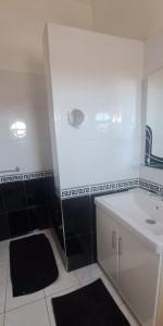 une salle de bain blanche avec un lavabo et un miroir dans l'établissement Riad Diaz Taghazout, à Ikouzza