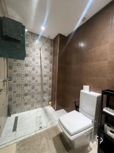 a bathroom with a toilet and a shower at Cozy apartment Beach and Souk within walking distance in Tangier +9 photos