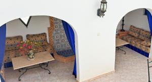 une chambre avec deux canapés et une table avec des fleurs dans l'établissement Riad Diaz Taghazout, à Ikouzza