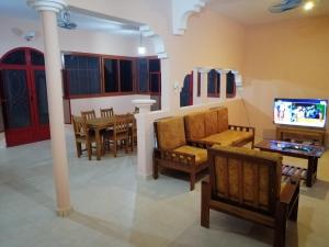 a living room with chairs and a tv and a table at Casa Michel in Saint-Louis +4 photos