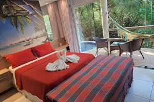 a bedroom with a red bed and a balcony at Villas do Pratagy in Maceió