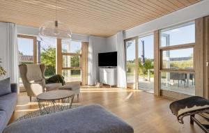 a living room with a couch and a tv at 3 Bedroom Stunning Home In Karrebæksminde in Enø By