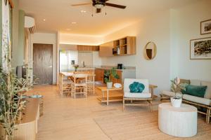 a living room and kitchen with a table and chairs at Yucalpeten Resort Marina - Dpto de 2 Recámaras en Progreso - Lujo Frente a la Playa & Amenidades Top in Progreso