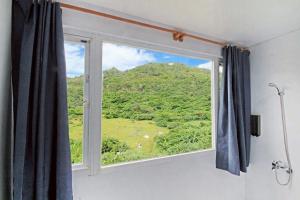 a window with a view of a mountain at House16 in Green Island