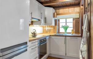 a kitchen with white cabinets and a window at Amazing Home In Trysil With House A Mountain View in Mælem