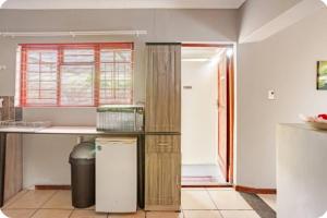 a kitchen with a counter and a refrigerator in a room at Self-catering Garden Cottage in Oudtshoorn