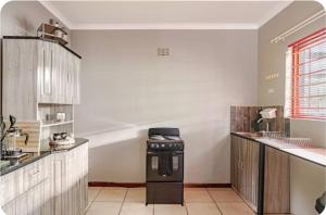 a kitchen with a stove top oven in a room at Self-catering Garden Cottage in Oudtshoorn