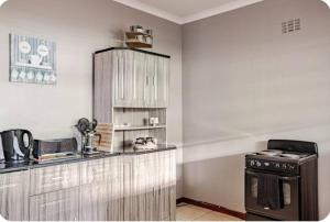 a kitchen with a counter and a stove in it at Self-catering Garden Cottage in Oudtshoorn