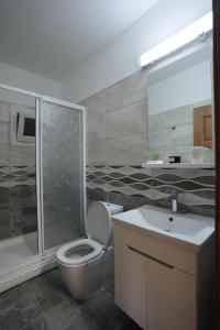 a bathroom with a toilet and a shower and a sink at Iskele Royal Sun Long Beach penthouse in Iskele