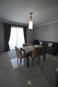 a living room with a table and chairs and a couch at Iskele Royal Sun Long Beach penthouse in Iskele