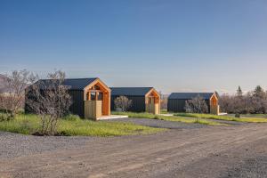 a row of houses on the side of a dirt road at Golden Circle Cabins in Laugarvatn