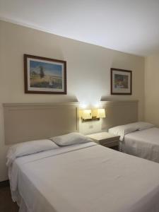 a hotel room with two beds and two pictures on the wall at Hotel La Mansión in Río Bravo +28 photos