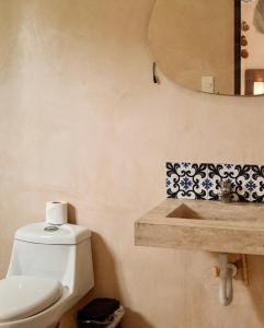 a bathroom with a toilet and a sink at Hotel Casa Nudo, Chukum, Mérida in Mérida