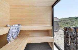 a sauna with a wood paneled wall and a window at Beach Front Home In Hvide Sande With Sauna in Hvide Sande +9 photos
