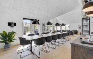 a long dining room with a long table and chairs at Beach Front Home In Hvide Sande With Sauna in Hvide Sande