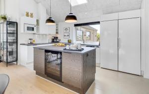 a kitchen with white cabinets and a large island at Beach Front Home In Hvide Sande With Sauna in Hvide Sande