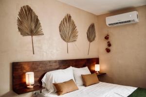 a bedroom with a bed with two lights on the wall at Hotel Casa Nudo, Chukum, Mérida in Mérida