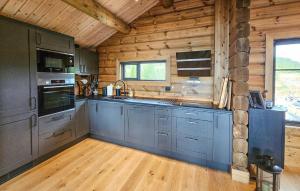 a kitchen with blue cabinets and a wooden ceiling at Nice Home In Gol With Sauna in Holtegard