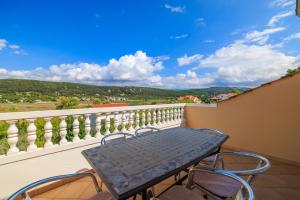 a table and chairs on a balcony with a view at Apartments Mig in Supetarska Draga
