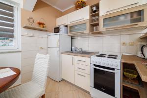 a kitchen with white appliances and a wooden table at Apartments Mig in Supetarska Draga +60 photos
