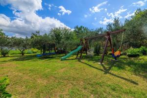 a playground with three swings in a yard at Apartments Mig in Supetarska Draga +61 photos