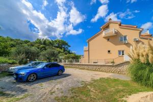 a blue car parked in front of a house at Apartments Mig in Supetarska Draga