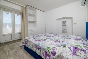 a bedroom with a bed with a floral bedspread at Apartment Pavilion in Kampor +30 photos